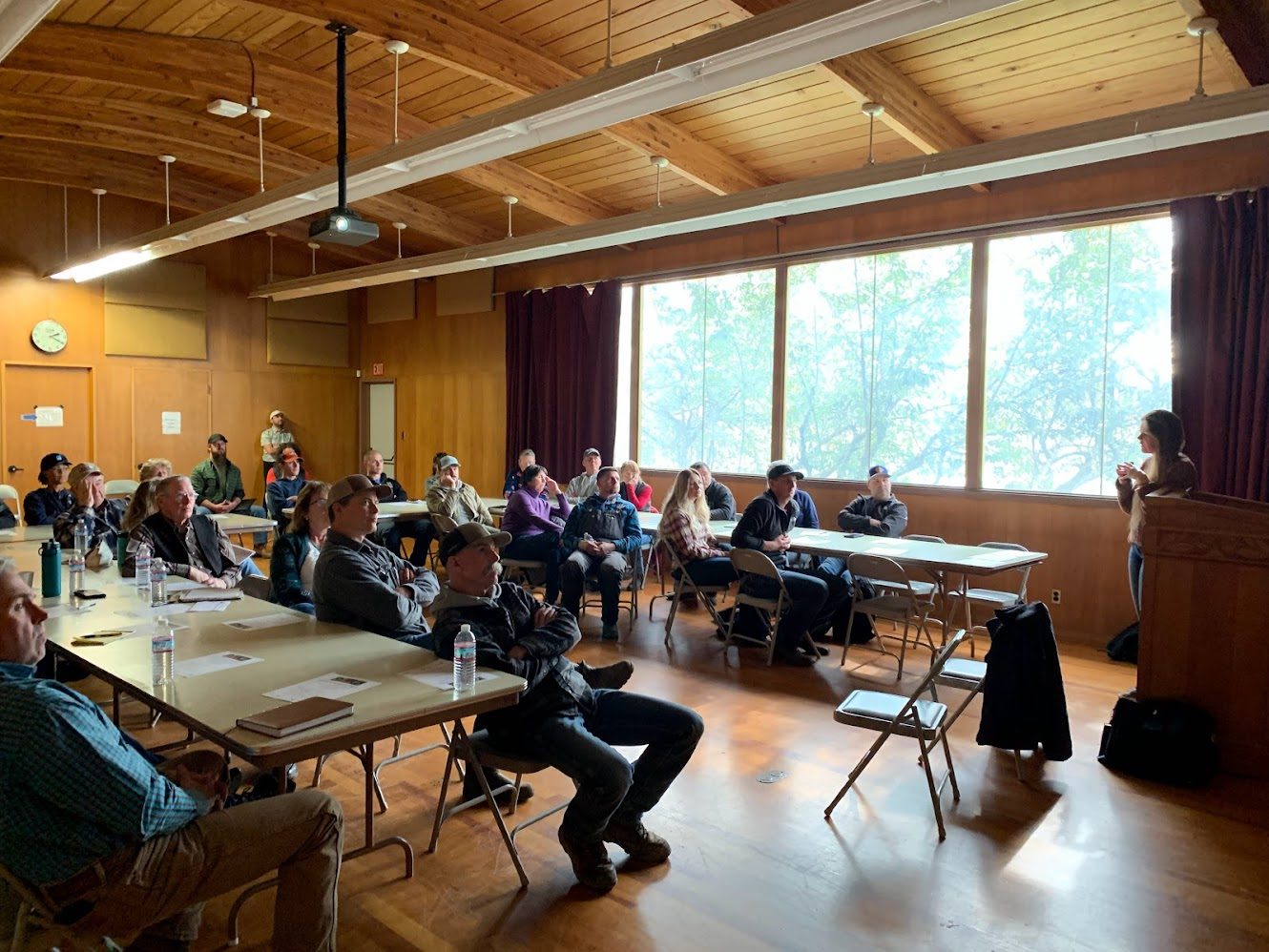 Participants seated at tables during a stakeholder workshop in a wood-panelled hall